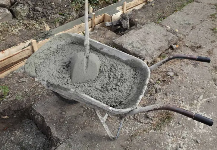 Taczka z betonem i łopatą, gotowa do wykonania zbrojenia ławy fundamentowej 40x60.