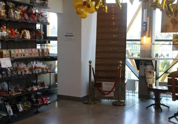 Wnętrze pijalni czekolady w Sanoku. Półki uginają się pod ciężarem słodkości, a złote balony zapowiadają wyjątkowe okazje.