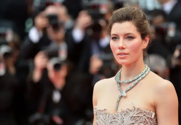 Jessica Biel w olśniewającej kreacji i biżuterii w kształcie węża, przypominającej sceny z jej filmów, pozuje na czerwonym dywanie.