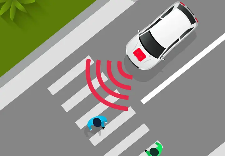 Coche eléctrico blanco se acerca a un paso de peatones. El sonido de los coches eléctricos es casi inaudible, pero las ondas rojas indican su presencia.