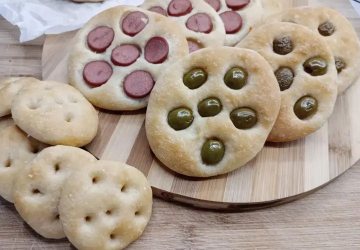 Focaccine di semola con olive e wurstel, pronte per essere gustate.