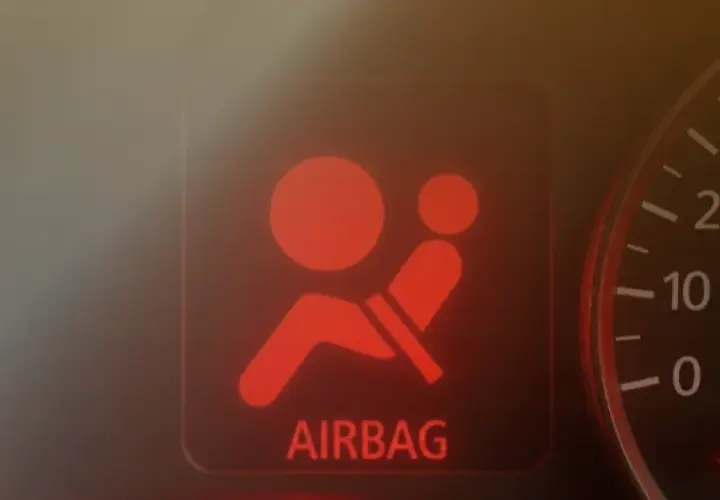 Spia rossa airbag accesa sul cruscotto. Un segnale di avvertimento che indica un problema, rendendo il ripristino airbag obbligatorio per la sicurezza.