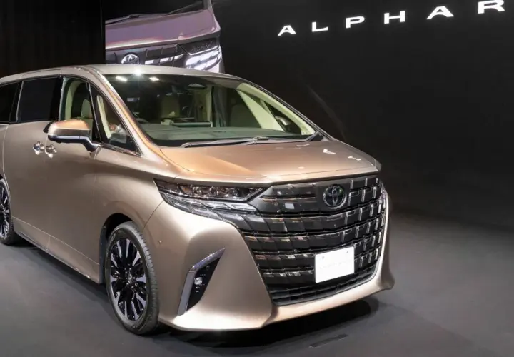 Elegancki, brązowy Toyota Alphard prezentuje się na czarnym tle.
