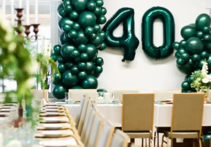 Elegancka impreza urodzinowa dla dorosłych z balonami tworzącymi liczbę 40. Uroczysty stół z zastawą i świecami.