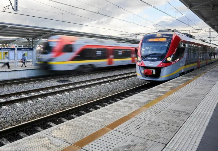 Nowoczesny pociąg PKP Intercity zbliża się do stacji Łódź Kaliska. W tle widać drugi pociąg w ruchu.