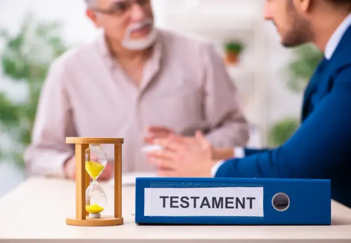 Klepsydra i segregator z napisem "TESTAMENT" na stole, podczas rozmowy dwóch mężczyzn.