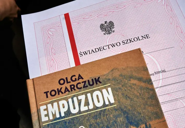 Świadectwo z paskiem i książka "Empuzjon" Olgi Tokarczuk. Symboliczne połączenie edukacji i literatury.