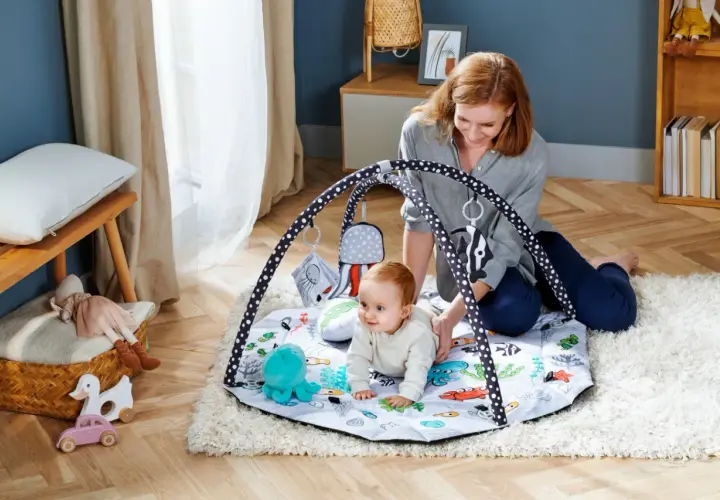 Mama bawi się z niemowlakiem na macie edukacyjnej dla niemowląt od kiedy tylko zacznie raczkować. Kolorowa mata z zabawkami zachęca do odkrywania świata.