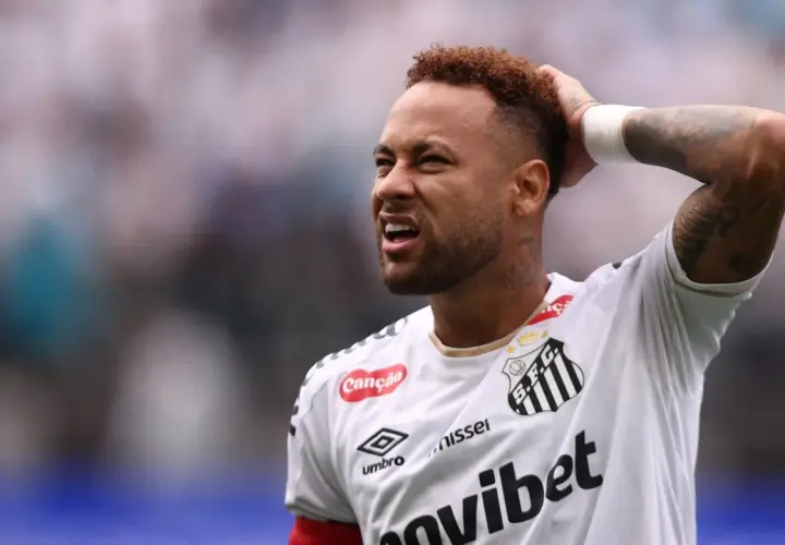 Neymar z grymasem na twarzy, trzymający się za głowę, sugeruje ból po kontuzji.