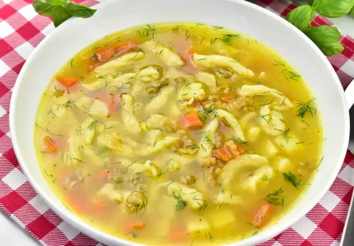 Aromaticzna zupa zacierkowa z kawałkami marchewki i ziemniaków, posypana świeżym koperkiem. Idealna na chłodne dni.