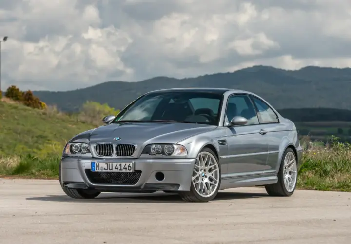 Srebrne BMW E46 coupe na tle górskiego krajobrazu.