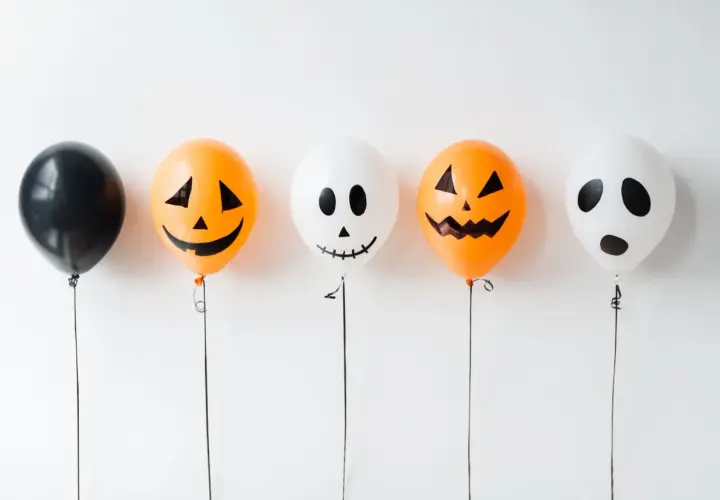 Fünf Ballons für Halloween basteln: ein schwarzer, zwei Kürbis-Ballons und zwei Geister-Ballons.