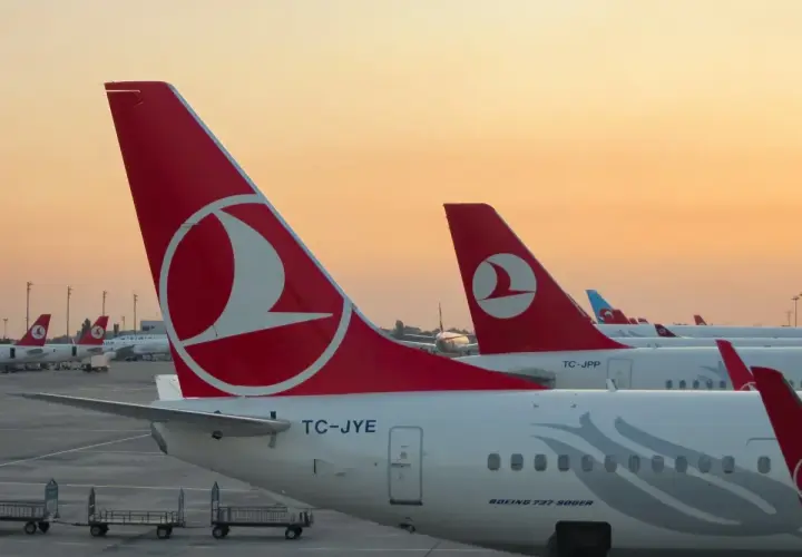 O zachodzie słońca samoloty Turkish Airlines czekają na pasażerów i ich bagaż.