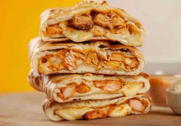 Scaccia ragusana ripiena di pollo e formaggio filante, un sapore unico.