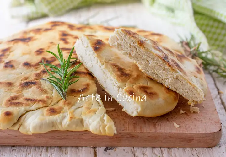 Una crescia umbra appena sfornata, dorata e profumata, con un rametto di rosmarino fresco.