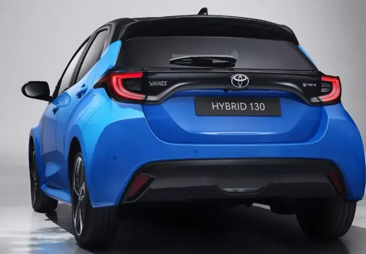 Niebieski hatchback Toyota Yaris IV z czarnym dachem i napisem HYBRID 130 z tyłu.