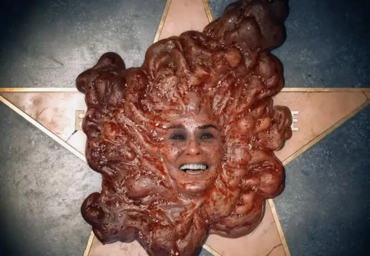 Volto umano emergente da una massa carnosa e pulsante, un'immagine disturbante tipica del **film body horror**.