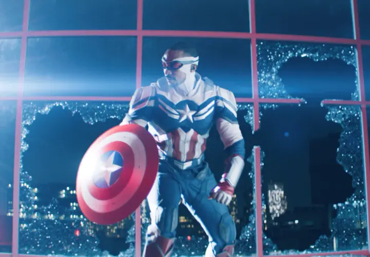 Sam Wilson, nouveau Captain America, prêt pour sa sortie MCU, tient son bouclier devant une fenêtre brisée.