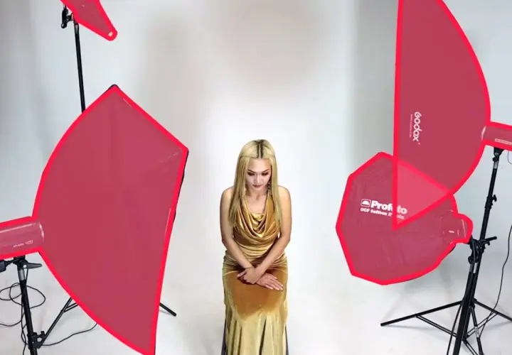 Modelka w złotej sukni, otoczona różnymi rodzajami oświetlenia w fotografii studyjnej.