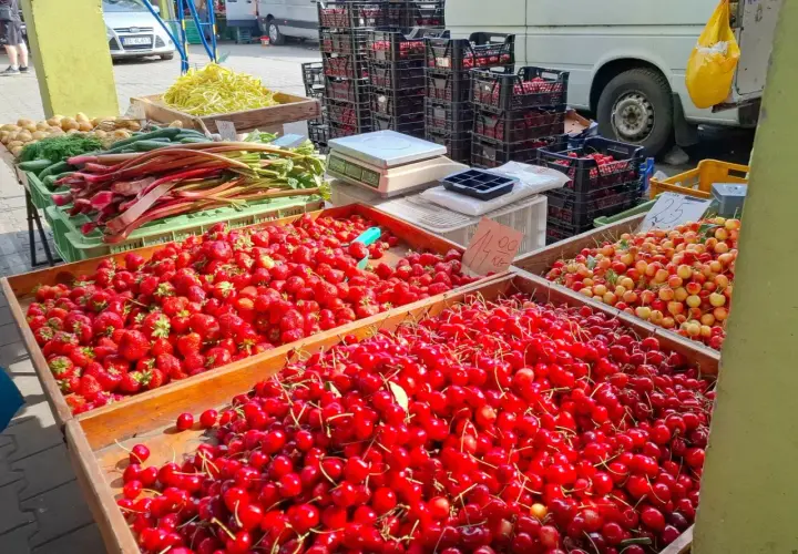 Targowisko pełne świeżych owoców. Duże skrzynie z truskawkami i czereśniami. Sprawdź czereśnie cenę za kilogram!