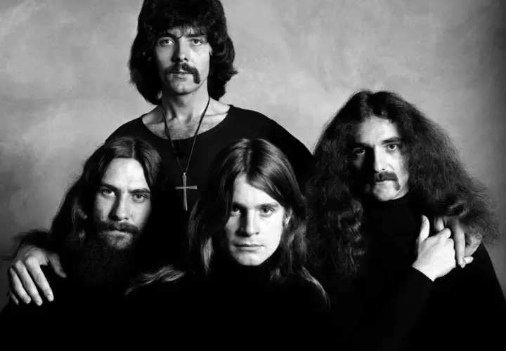 Czterech członków zespołu Black Sabbath, twórców kultowych utworów, pozuje do czarno-białego zdjęcia.