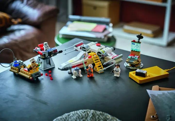 Lego Star Wars X-Wing mit Figuren und einem kleinen, smarten Lego brick auf einer gelben Ladestation.