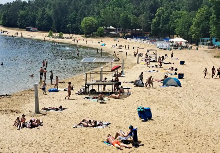 Słoneczna plaża Skorochów tętni życiem. Ludzie kąpią się, opalają i odpoczywają na piasku, ciesząc się letnim dniem.