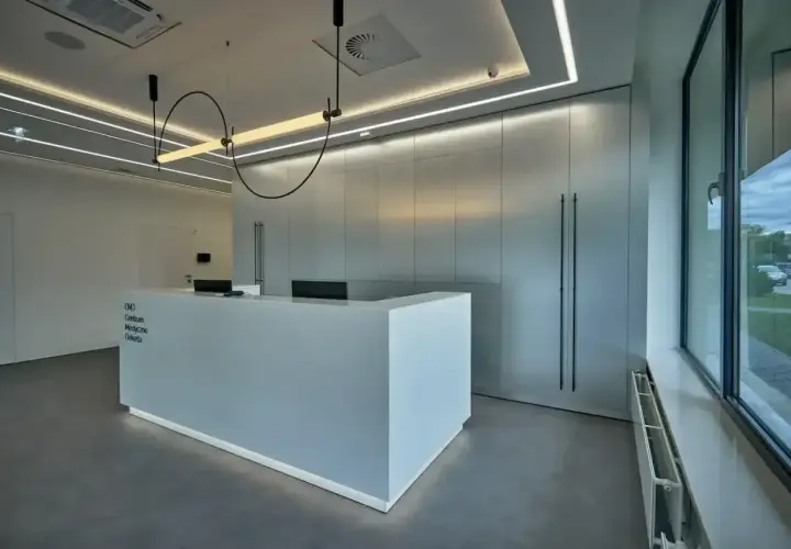 Nowoczesne centrum medyczne z recepcją i minimalistycznym wystrojem.