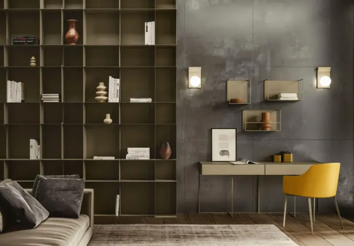 Ein moderner schreibtisch im wohnzimmer, neben einem Sofa und einem großen Regal. Ein gelber Stuhl steht davor.