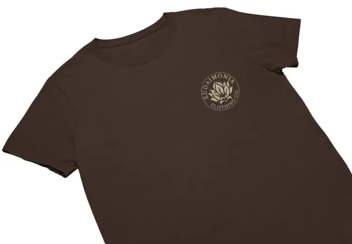 T-shirt marron avec un logo brodé d'une fleur de lotus et du texte "Eudaimonia Clothing Co.".