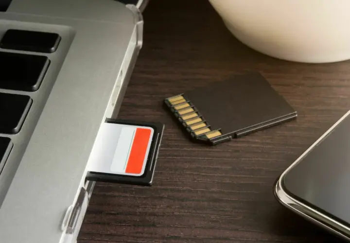SD-Karte wird nicht erkannt in Windows 10? Ein Laptop, eine SD-Karte im Slot und eine daneben liegende Karte deuten auf ein Problem hin.