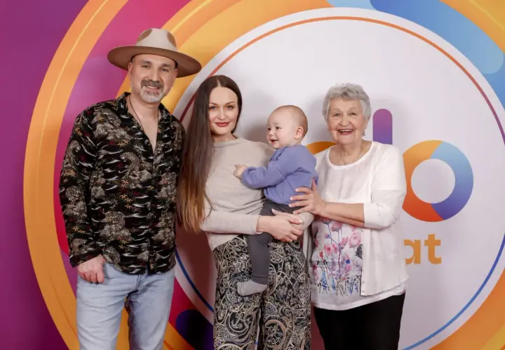 Mateusz Ziółko z rodziną: żoną, synkiem i mamą na tle kolorowego logo.