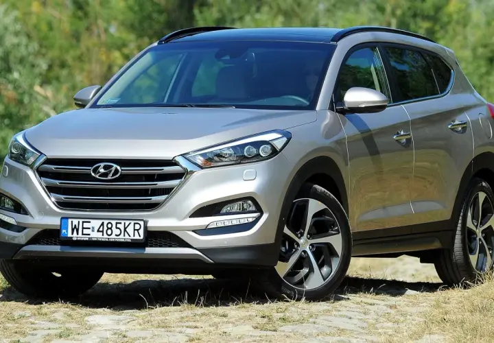Srebrny Hyundai Tucson 3 na tle zieleni.