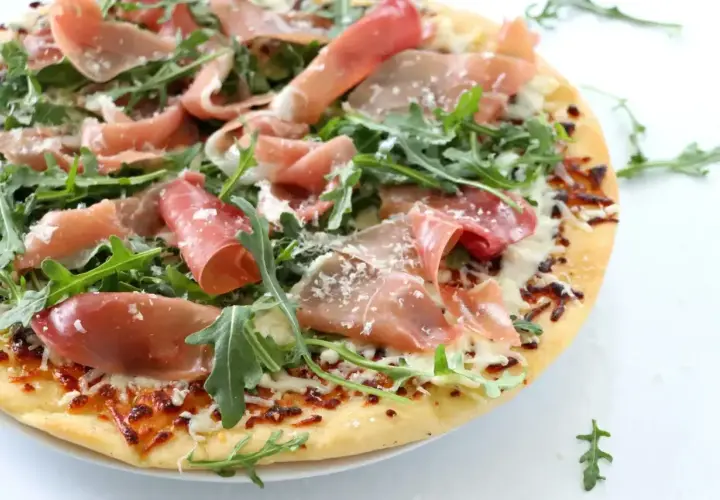 Pizza crudo z rukolą i parmezanem, pachnąca słońcem Włoch.