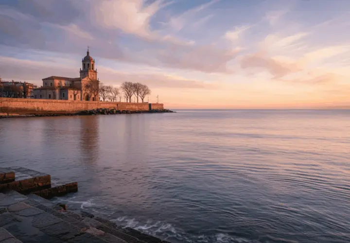 Edificio histórico junto al mar al amanecer, evocando poemas del mar.