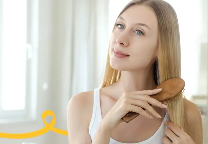 Kobieta szczotkuje włosy, przygotowując domowy peeling do skóry głowy.