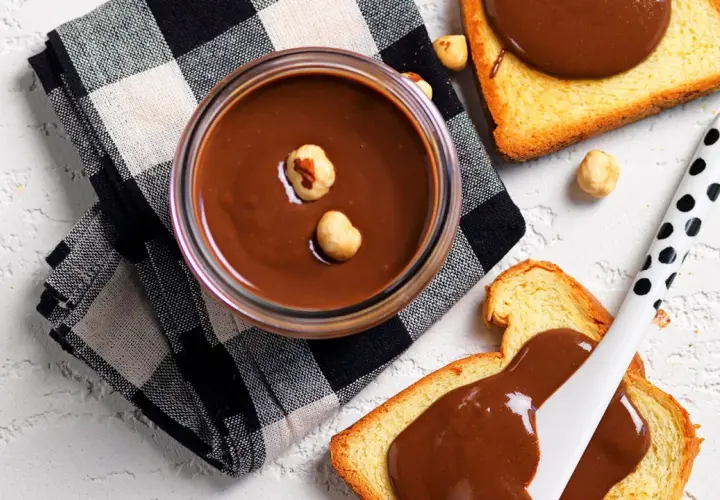 Crema di nocciole fatta in casa, vellutata e invitante, su fette di pane tostato. Un piacere da gustare!