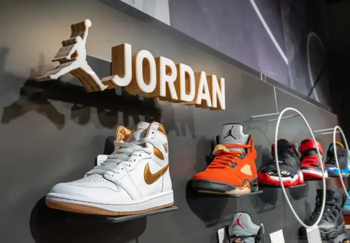 Na ścianie widnieje logo Jordan i nazwa marki. Na półkach wyeksponowane są kultowe buty Jordan Air w różnych kolorach.