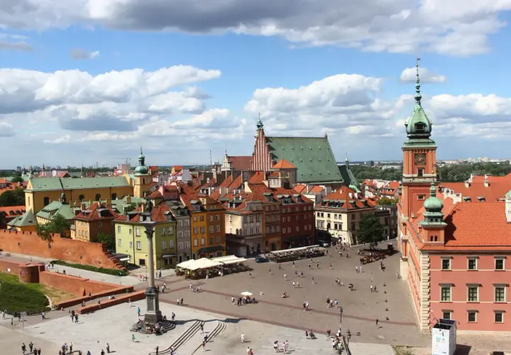 Widok na Zamek Królewski i Rynek Starego Miasta w Warszawie. Kolorowe kamienice, kolumna Zygmunta i tłumy turystów.