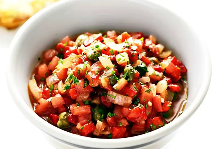 En skål med färsk salsa, perfekt för ditt salsa recept. Tomater, lök och örter blandas till en läcker röra.