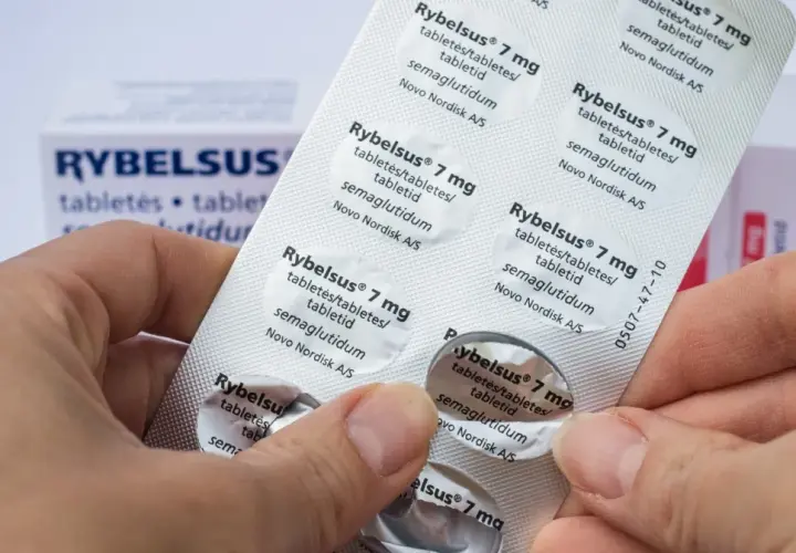Dłonie trzymają opakowanie leku Rybelsus, który jest lekiem na cukrzycę. Widać tabletki z semaglutydem.