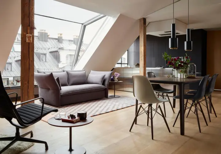 Modernes Wohnzimmer mit Dachfenster: Hier lässt sich Sofa und Esstisch gut kombinieren. Graues Sofa, Holzboden, schwarzer Esstisch mit Stühlen.