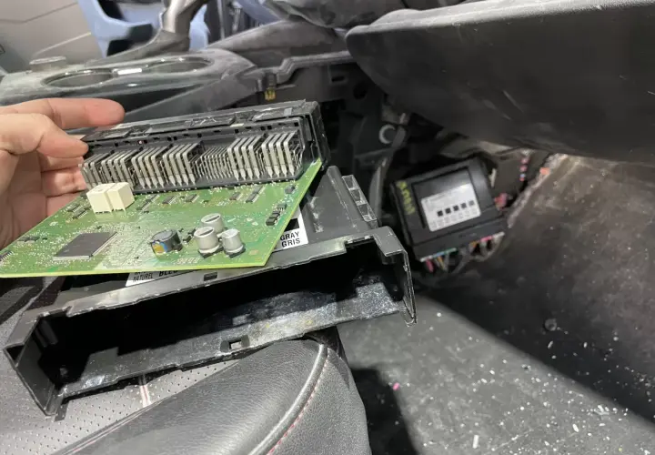 Naprawa modułu komfortu w Oplu, błąd dtc u0140. Widoczna zielona płytka drukowana z elementami elektronicznymi.