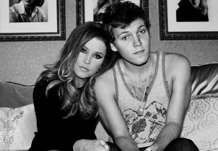Lisa Marie Presley z synem Benjaminem Keough, siedzą blisko siebie na kanapie.