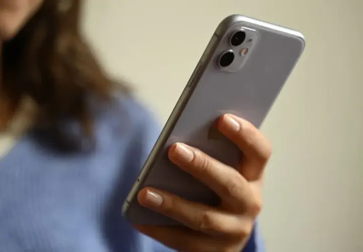 Frau hält Handy, fragt sich: "Angeblich Lotto-Abo abgeschlossen, was tun?