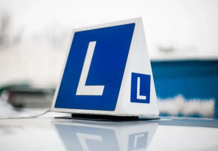 Tablica z literą "L" na dachu samochodu. Zastanawiasz się, ile kosztuje prawo jazdy na raty?
