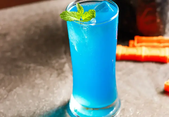 Błękitny drink z miętą i lodem w szklance.