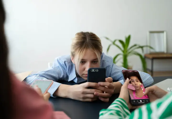 Młodzi ludzie pochłonięci smartfonami, być może doświadczający nomofobii. Co to za zjawisko?