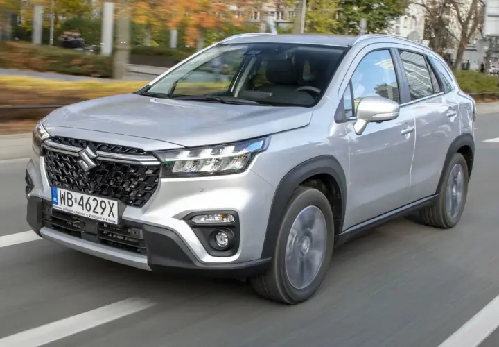 Srebrny Suzuki S-Cross w ruchu miejskim. Wiele osób szuka **Suzuki S-Cross opinie** przed zakupem.