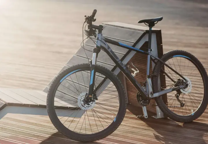 Szary rower crossowy z niebieskimi akcentami, idealny na wycieczki i do jazdy po trudniejszym terenie. Ten rower mtb czeka na przygodę.